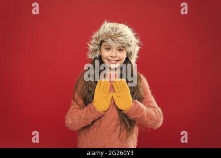 happy teen girl wear warm clothes. feel comfortable and cozy in any weather. winter holiday and vacation. kid in hat with ear flaps. child in knitted Stock Photo