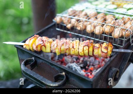 vegetables, mushrooms and potatoes with bacon on the fire Stock Photo