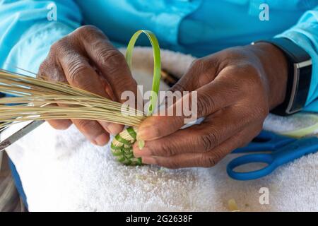 A descendent of slaves, this woman Gullah Geechee master sweetgrass basket weaver creates traditional cultural art on Sapelo Island, Georgia. Stock Photo