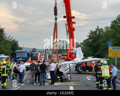 Gelnhausen, Germany. 08th June, 2021. Firefighters used a crane to recover the wreckage of a crashed small plane from the embankment of a road. Two people were killed in the crash. Credit: Michael Seeboth/dpa/Alamy Live News Stock Photo