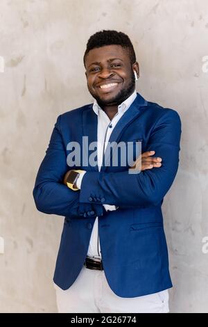 Head shot portrait handsome african american young businessman cross arms with healthy smile in classic suit pose isolated on gray office background Stock Photo