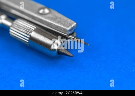 Close-up of drawing compass on blue bright background Stock Photo