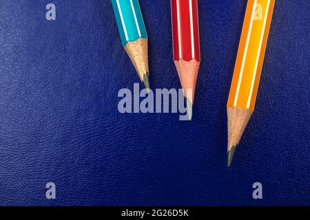 Close-up of sharp school pencils on a blue leather background, copy space Stock Photo