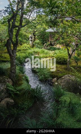 Kyoto, Japan - 18 September 2017: Natural Japanese zen garden Sogenchi with river running in lush forest landscape at temple Tenryu-ji Stock Photo