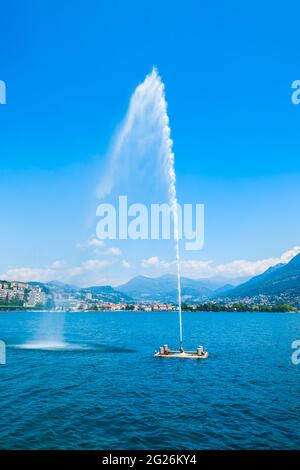 Fountain at Lugano lake and Lugano city panoramic view in canton of Ticino in Switzerland Stock Photo