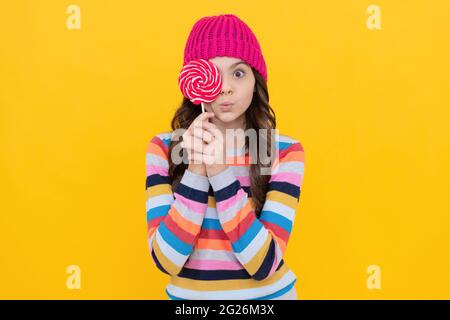 surprised teen girl hold lollipop. lollipop lady. hipster kid with colorful lollypop sugar candy Stock Photo