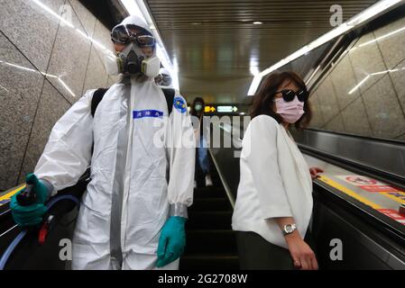 Taipei, Taiwan. 8th June, 2021. A Taiwanese solder in full PPE gear passes a commuter on an escalator as military troops disinfect public areas and transport in Taipei, following a serious outbreak with an increasing number of domestic infections and deaths related to the COVID-19 disease. Credit: Daniel Ceng Shou-Yi/ZUMA Wire/Alamy Live News Stock Photo