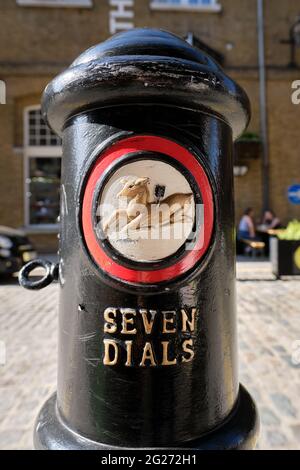 Close-up of a black traffic bollard featuring the distinctive white, red and gold Seven Dials insignia and wording Stock Photo