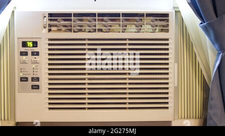 A Close Up of a Window Air Conditioner in a Home Window Stock Photo