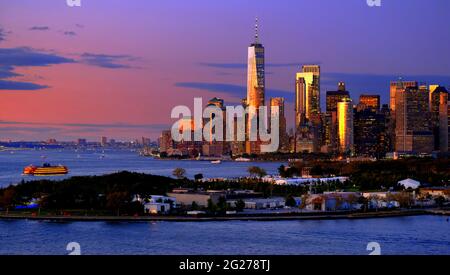 USA; NEW YORK CITY; LOWER MANHATTAN SKYLINE AT DUSK; STATEN ISLAND FERRY; FREEDOM TOWER; GOVERNOR'S ISLAND IN FOREGROUND Stock Photo