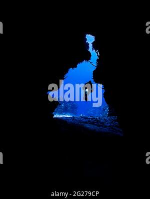 Silhouette of a scuba diver with light outside a cavern in Cozumel, Mexico. Stock Photo