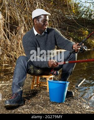 Man fishing with rods on river Stock Photo