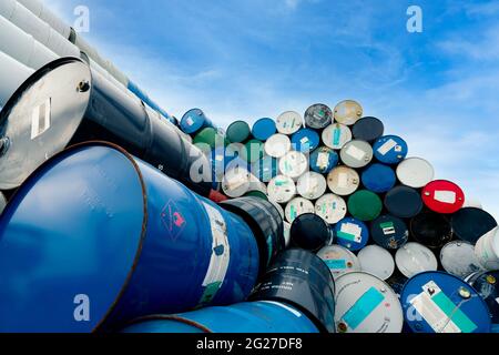 Old chemical barrels. Blue oil drum with flammable liquid symbol. Toxic waste warehouse. Hazard chemical tank with warning label. Industrial waste. Stock Photo