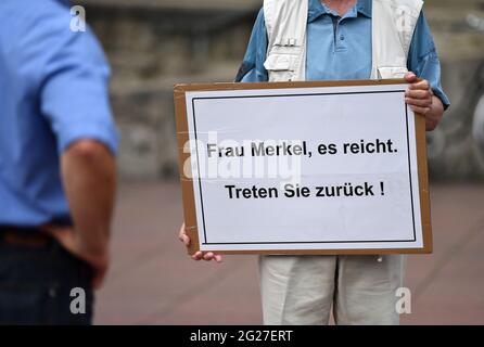 Weimar, Germany. 08th June, 2021. A man holds a placard reading "Frau Merkel, es reicht. Step back" in his hands and stands on Theaterplatz in front of the German National Theatre in Weimar. Credit: Martin Schutt/dpa-Zentralbild/dpa/17�Թ����� Live News Stock Photo