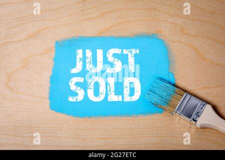 JUST SOLD. Paint brush with blue paint on a wooden surface. Stock Photo