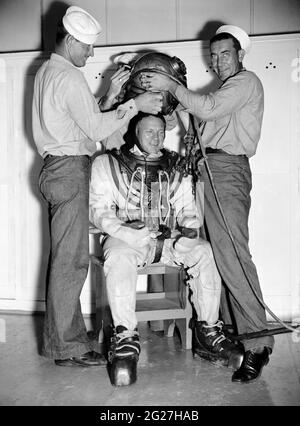 A Master Diver in the U.S. Navy being helped into his underwater suit. Stock Photo