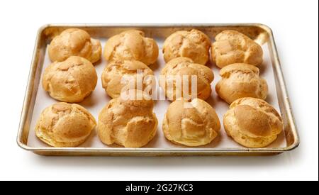 freshly baked cream puffs on baking pan isolated on white background Stock Photo