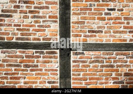 Facade of an old half-timbered house. Wooden structure filled with red bricks. Old robust construction. Stock Photo