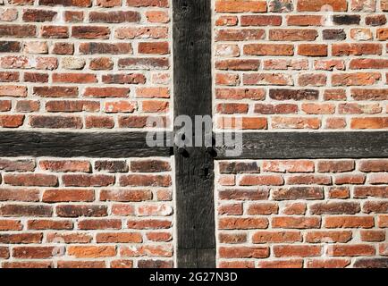Facade of an old half-timbered house. Wooden structure filled with red bricks. Old robust construction. Stock Photo