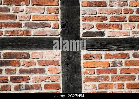 Facade of an old half-timbered house. Wooden structure filled with red bricks. Old robust construction. Stock Photo
