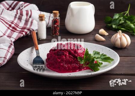 Salad of grated beetroot pine nuts and parsley with cream sauce on a plate Stock Photo