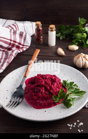 Salad of grated beetroot pine nuts and parsley with cream sauce on a plate Stock Photo