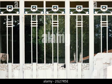 detail of a white wooden door with glass and wrought iron with floral motifs Stock Photo