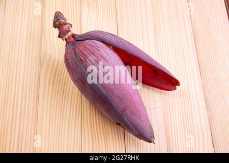Fresh Banana Blossom or Banana flower, edible vegetable mostly used in south east asia,arranged on wooden textured table Stock Photo