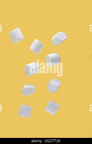 flying food concept - marshmallow levitating against yellow background. Image contains copy space Stock Photo
