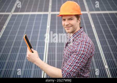 Smiling man in safety helmet while working Stock Photo
