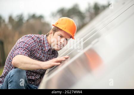 Man in helmet checking surface of object Stock Photo