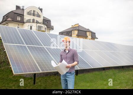 Smiling man with drawing on solar panel background Stock Photo