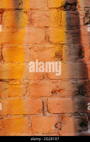 Multicolored brick wall in vibrant colors of orange and yellow. Stock Photo