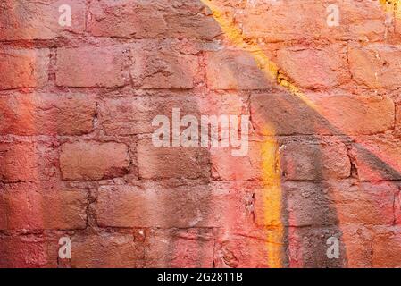 Multi-colored brick wall in vibrant burgundy and yellow colors. Stock Photo