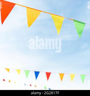 Fair ribbon made of multicolored triangles against the sky. Stock Photo