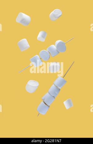 flying food concept - marshmallows on skewers levitating against yellow background. Image contains copy space Stock Photo