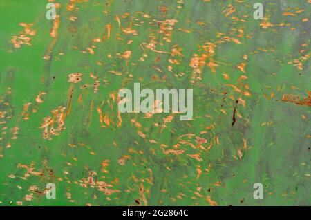 Chaotic yellow Dots and spots of rust on the green painted metal wall. Rusty metal and paint.  Corroded metal background. Stock Photo