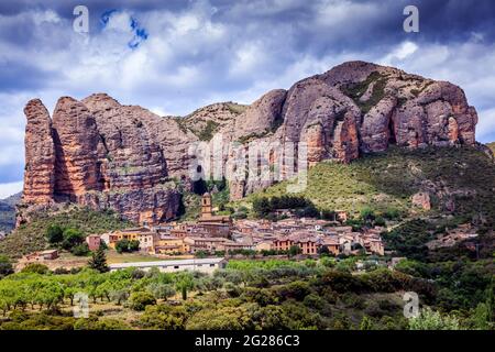 The Mallos de Aguero stand behind the village with the same name.  Impressive red rocks with vertical walls, very appreciated by climbers. Spain. Stock Photo