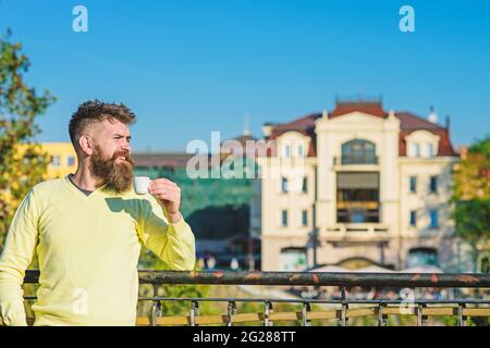 Man with long beard enjoy coffee. Morning ritual concept. Bearded man with little mug, drinks coffee. Man with beard and mustache on smiling face Stock Photo