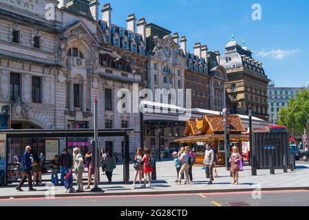 People waiting at a bus stop outside Victoria railway station. London, England, UK Stock Photo