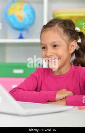 Porait of cute girl using laptop at home at desk Stock Photo - Alamy
