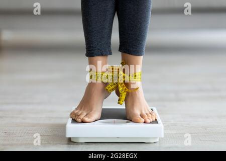 https://l450v.alamy.com/450v/2g28egx/unrecognizable-indian-woman-standing-on-scales-with-tied-feet-checking-her-weight-2g28egx.jpg