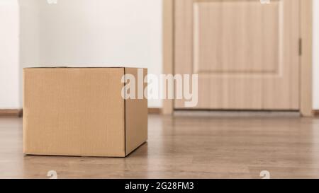 Delivered Cardboard Box Parcel Lying Near Door Of Customer's House Stock Photo