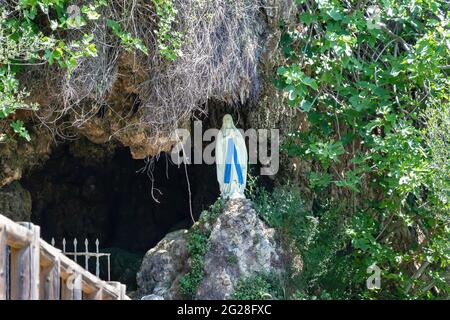 Higuera de la Sierra, Huelva, Spain - April  17, 2021: Image of the Virgin in her invocation of Our Lady of Lourdes in a cave on the pathway de las To Stock Photo