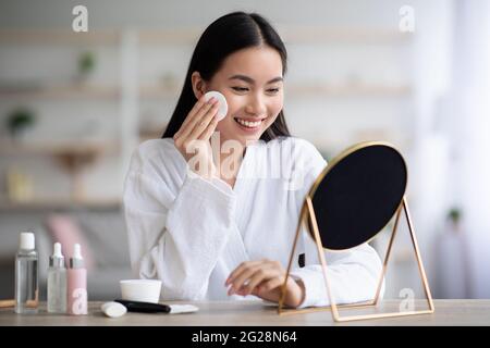 Beautiful asian woman cleaning her face with toner Stock Photo