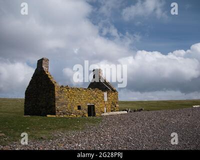 An abandoned, derelict croft or farm house on a pebble beach at Stenness, Northmavine in  Shetland, Scotland, UK Stock Photo