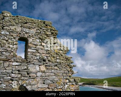 With beard moss lichen, the gable end wall at St Olaf's Church at Lunda Wick, Unst, Shetland, UK - taken on a sunny day Stock Photo