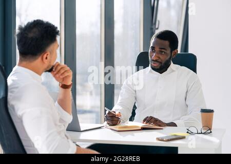 Business meeting in office. Employment interview. Two business partners are talking while sitting at the table Stock Photo