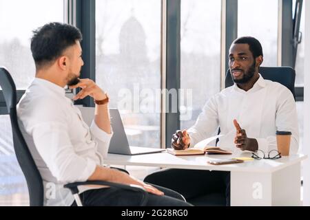 Business meeting in office. Employment interview. Two business partners are talking while sitting at the table Stock Photo