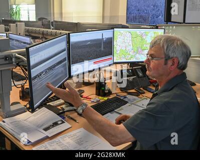 09 June 2021, Brandenburg, Wünsdorf: Wilfried Pasewald, coordinator of the Forest Fire Center South of the Brandenburg State Forestry Office in Wünsdorf, sits in front of computer screens. With the rising temperatures, the danger of forest fires has increased in Brandenburg. Currently, forest fire danger level 4 is in effect throughout the state of Brandenburg. Two forest fire centers in Wünsdorf (Teltow-Fläming) and Eberswalde (Barnim) monitor what is happening in the state. From stage 3 onwards, they are manned. According to the Ministry of the Environment, last year there were 299 forest fi Stock Photo